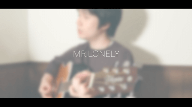 ギターを弾いている日景健貴と『MR.LONELY』とタイトルが書かれた写真